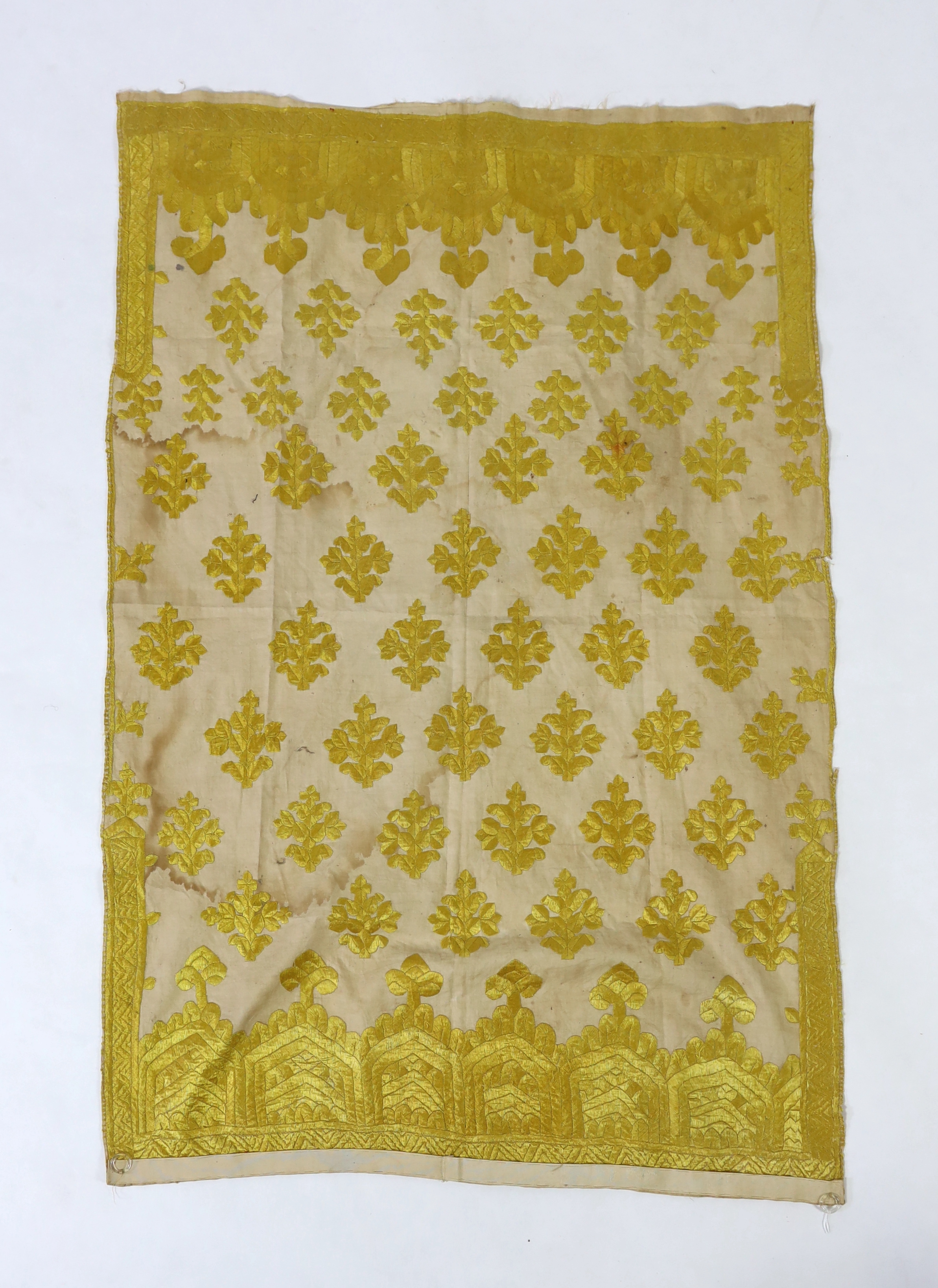 An early 20th century North Indian cotton yellow silk hand embroidered panel, with wide embroidered borders and all over stylistic spot motifs, 122 cm long x 80cm wide